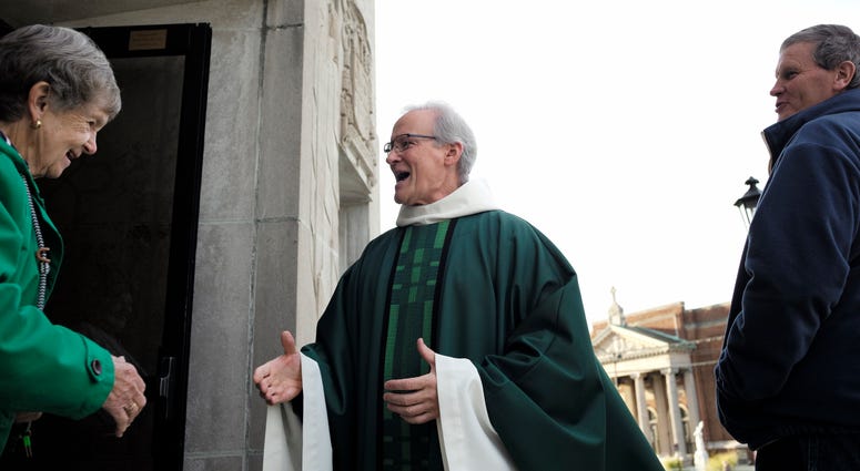 In this Sunday, Oct. 20, 2019 photo, Rev. William Tourigny, 66, center, pastor of St. Rose de Lima Parish, in Chicopee, Mass., greets parishioners following Mass in front of the Catholic church. Catholic church in Massachusetts
