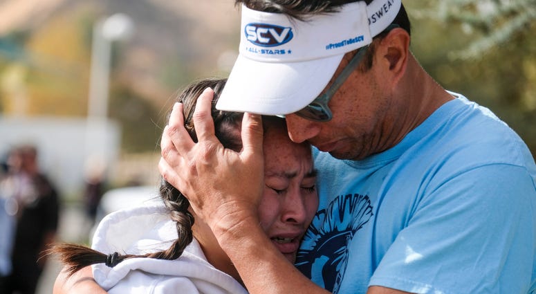 Ella Cabigting is embraced by her father Emerson as they reunite following a shooting at Saugus High School that injured several people, Thursday, Nov. 14, 2019, in Santa Clarita, Calif. Ella Cabigting is embraced by her father Emerson as they reunite following a shooting at Saugus High School that injured several people, Thursday, Nov. 14, 2019, in Santa Clarita, Calif.