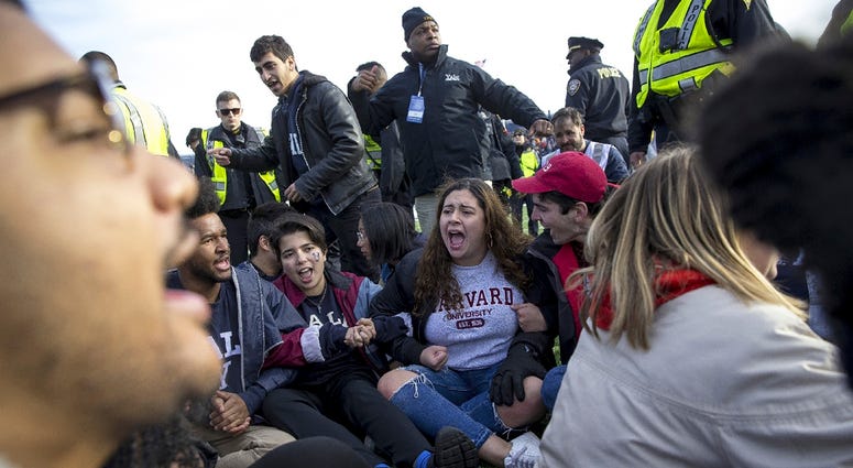 In this Saturday, Nov. 23, 2019, photo, Harvard and Yale students protest during halftime of the NCAA college football game between Harvard and Yale at the Yale Bowl in New Haven, Conn. Harvard-Yale game protest