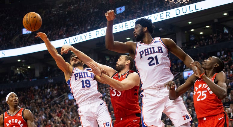 Philadelphia 76ers guard Raul Neto (19) jumps for a rebound ahead of Toronto Raptors' Marc Gasol (33) as 76ers' Joel Embiid (21) and Raptors' Chris Boucher (25) and Rondae Hollis-Jefferson (4) look on during the first half of an NBA basketball game. Philadelphia 76ers guard Raul Neto (19) jumps for a rebound ahead of Toronto Raptors' Marc Gasol (33) as 76ers' Joel Embiid (21) and Raptors' Chris Boucher (25) and Rondae Hollis-Jefferson (4) look on during the first half of an NBA basketball game.