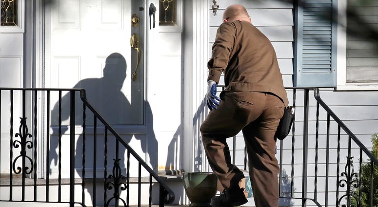 A UPS driver delivers an Amazon package to a residence in North Andover, Mass. A UPS driver delivers an Amazon package to a residence in North Andover, Mass.