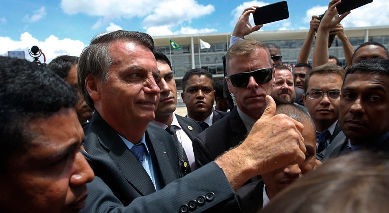 Brazil's President Jair Bolsonaro flashes a thumbs up as he greets supporters after attending a Changing of the Guard at the Planalto Presidential Palace, in Brasilia, Brazil, Thursday, Nov. 28, 2019. Brazil's President Jair Bolsonaro flashes a thumbs up as he greets supporters after attending a Changing of the Guard at the Planalto Presidential Palace, in Brasilia, Brazil, Thursday, Nov. 28, 2019.
