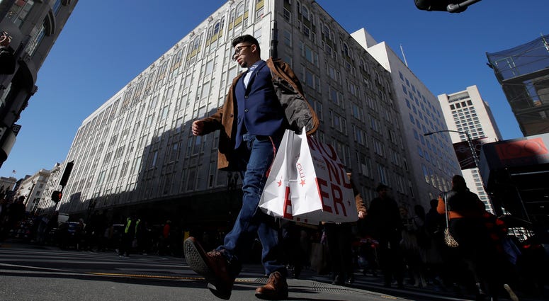 A man carries shopping bags across the street from a Macy's store in San Francisco, Friday, Nov. 29, 2019. Black Friday once again kicked off the start of the holiday shopping season. A man carries shopping bags across the street from a Macy's store in San Francisco, Friday, Nov. 29, 2019. Black Friday once again kicked off the start of the holiday shopping season.