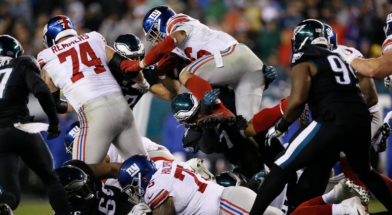New York Giants' Saquon Barkley (26) leaps over Philadelphia Eagles' Daeshon Hall (74) during the first half of an NFL football game, Monday, Dec. 9, 2019, in Philadelphia. New York Giants' Saquon Barkley (26) leaps over Philadelphia Eagles' Daeshon Hall (74) during the first half of an NFL football game, Monday, Dec. 9, 2019, in Philadelphia.