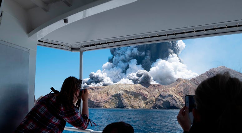 Tourists on a boat look at the eruption of the volcano on White Island, New Zealand, on Dec. 9, 2019. Tourists on a boat look at the eruption of the volcano on White Island, New Zealand, on Dec. 9, 2019.