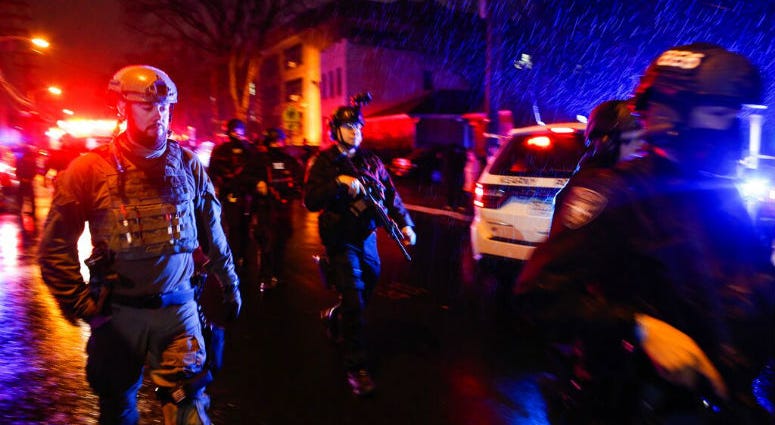 Law enforcement personnel walk near the scene following a shooting, Tuesday, Dec. 10, 2019, in Jersey City, N.J. Law enforcement personnel walk near the scene following a shooting.