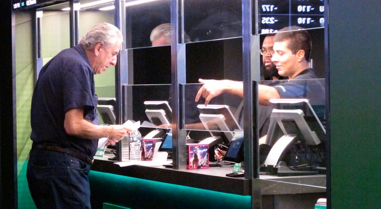 In this Oct. 8, 2019 photo, a man makes a sports bet at Resorts casino in Atlantic City, N.J. In November 2019, New Jersey's casinos and racetracks took in nearly $563 million worth of sports bets, a new monthly record. In this Oct. 8, 2019 photo, a man makes a sports bet at Resorts casino in Atlantic City, N.J. In November 2019, New Jersey's casinos and racetracks took in nearly $563 million worth of sports bets, a new monthly record.