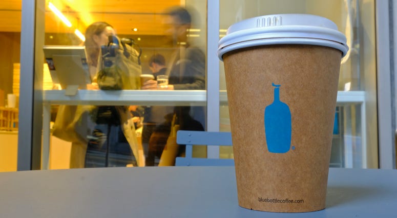 A Blue Bottle Coffee paper to-go cup rests on a table outside one of their cafes in San Francisco. A Blue Bottle Coffee paper to-go cup rests on a table outside one of their cafes in San Francisco.