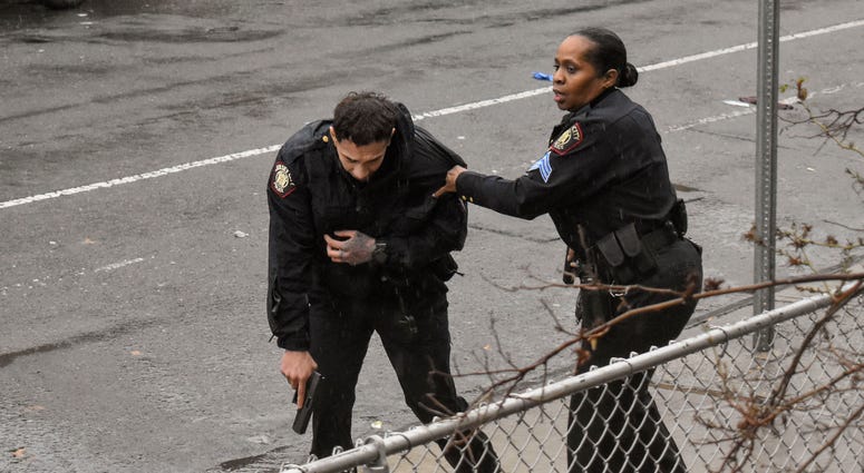 Jersey City police Sgt. Marjorie Jordan, right, helps fellow officer Raymond Sanchez to safety after he was shot during a gunfight that left multiple dead in Jersey City, N.J. Jersey City police Sgt. Marjorie Jordan, right, helps fellow officer Raymond Sanchez to safety after he was shot during a gunfight that left multiple dead in Jersey City, N.J.
