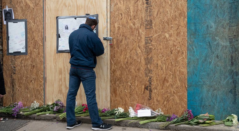 Alex Seligson pens a note of condolence Friday, Dec. 13, 2019 in Jersey City, N.J. at the boarded up kosher grocery store where three people and two gunmen were killed on Tuesday. Alex Seligson pens a note of condolence Friday, Dec. 13, 2019 in Jersey City, N.J. at the boarded up kosher grocery store where three people and two gunmen were killed on Tuesday.