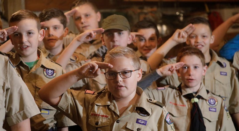 In this Thursday, Dec. 12, 2019 photo, a Boy Scouts troop salutes during their meeting, in Kaysville, Utah. Boy Scouts