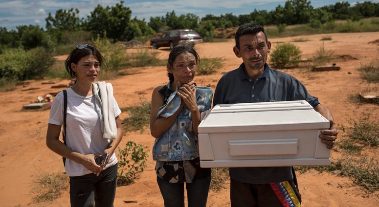 Roberto Parra carries the remains of his son Matias Alejandro alongside his wife Maria Isabel Parra and daughter Alejandra Parra at San Sebastian municipality cemetery before burying him in Maracaibo, Venezuela, Nov. 27, 2019. Roberto Parra carries the remains of his son Matias Alejandro alongside his wife Maria Isabel Parra and daughter Alejandra Parra at San Sebastian municipality cemetery before burying him in Maracaibo, Venezuela, Nov. 27, 2019.
