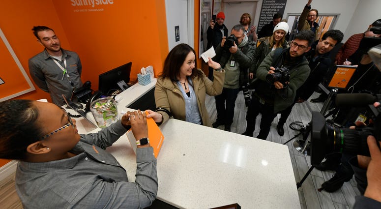 Jackie Ryan of Forest Park, Ill., becomes the first person in Illinois to purchase recreational marijuana as she purchases marijuana products from employee Brea Mooney left, at Sunnyside dispensary Wednesday, Jan. 1, 2020, in Chicago. Jackie Ryan of Forest Park, Ill., becomes the first person in Illinois to purchase recreational marijuana as she purchases marijuana products from employee Brea Mooney left, at Sunnyside dispensary Wednesday, Jan. 1, 2020, in Chicago.