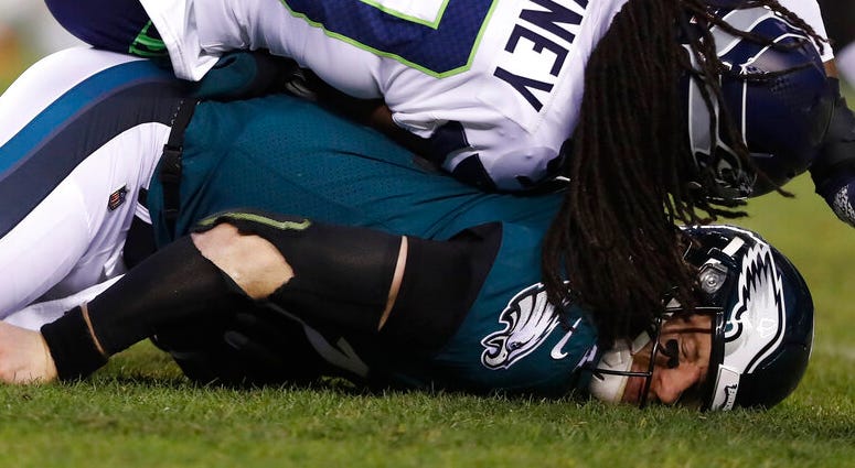 Philadelphia Eagles' Carson Wentz (11) is hit by Seattle Seahawks' Jadeveon Clowney (90) during the first half of an NFL wild-card playoff football game, Sunday, Jan. 5, 2020, in Philadelphia. Philadelphia Eagles' Carson Wentz (11) is hit by Seattle Seahawks' Jadeveon Clowney (90) during the first half of an NFL wild-card playoff football game, Sunday, Jan. 5, 2020, in Philadelphia.