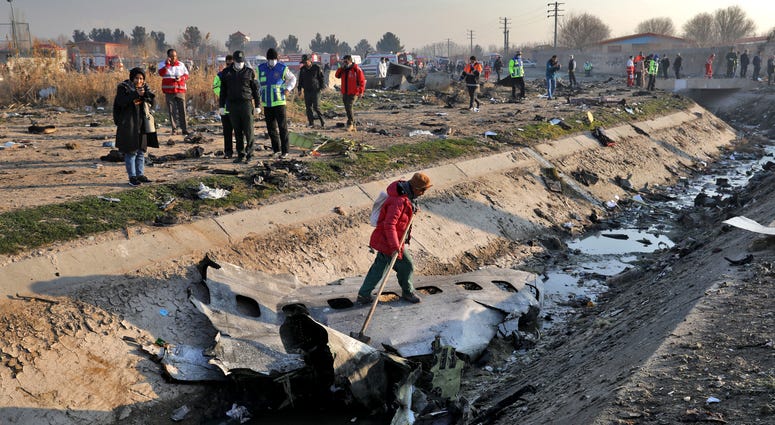 Rescue workers inspect the scene where a Ukrainian plane crashed in Shahedshahr, southwest of the capital Tehran, Iran, Wednesday, Jan. 8, 2020. Ukrainian plane crashed in Iran