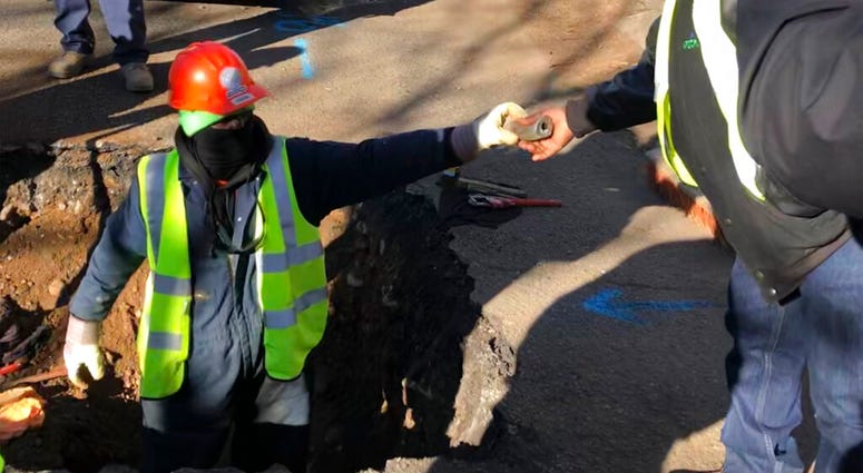 A worker hands a piece of lead pipe to a colleague as they work to remove water service lines Thursday, Jan. 9, 2020, in Trenton, N.J. A worker hands a piece of lead pipe to a colleague as they work to remove water service lines Thursday, Jan. 9, 2020, in Trenton, N.J.