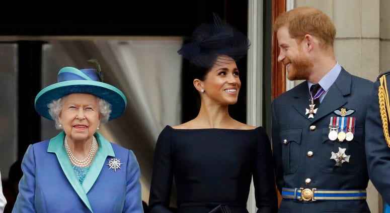 In this Tuesday, July 10, 2018 file photo Britain's Queen Elizabeth II, and Meghan the Duchess of Sussex and Prince Harry watch a flypast of Royal Air Force aircraft pass over Buckingham Palace in London. In this Tuesday, July 10, 2018 file photo Britain's Queen Elizabeth II, and Meghan the Duchess of Sussex and Prince Harry watch a flypast of Royal Air Force aircraft pass over Buckingham Palace in London.