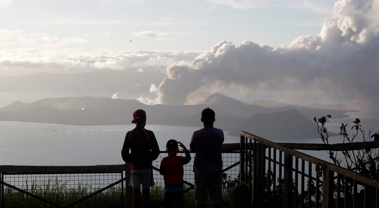 People watch from Tagaytay, Cavite province, south of Manila, as Taal Volcano continues to spew ash on Tuesday, Jan. 14, 2020. Taal Volcano