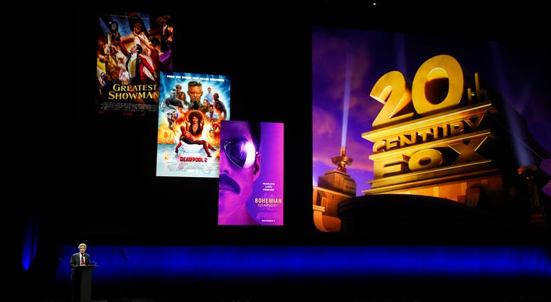 FILE - In this April 3, 2019, file photo, Alan Horn, chairman of The Walt Disney Studios, speaks underneath poster images for 20th Century Fox films during the Walt Disney Studios Motion Pictures presentation at CinemaCon 2019. FILE - In this April 3, 2019, file photo, Alan Horn, chairman of The Walt Disney Studios, speaks underneath poster images for 20th Century Fox films during the Walt Disney Studios Motion Pictures presentation at CinemaCon 2019.
