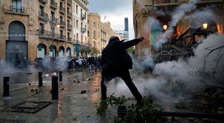 Riot police fired tears gas and sprayed protesters with water cannons near parliament building to disperse thousands of people after riots broke out during a march against the ruling elite amid a severe economic crisis. Anti-government protesters clash with the riot police, during a protest at a road leading to the parliament building in Beirut, Lebanon, Saturday.