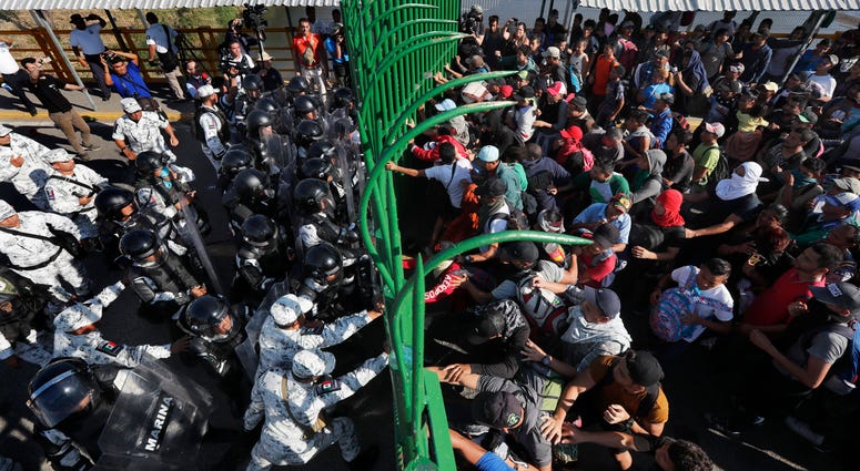 More than a thousand Central American migrants surged onto the bridge spanning the Suchiate River, that marks the border between both countries, as Mexican security forces attempted to impede their journey north. Migrants charge on the Mexican National Guardsmen at the border crossing between Guatemala and Mexico in Tecun Uman, Guatemala, Saturday.