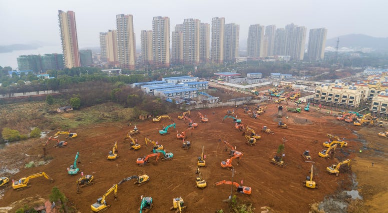 Heavy equipment works at a construction site for a field hospital in Wuhan in central China's Hubei Province. Heavy equipment works at a construction site for a field hospital in Wuhan in central China's Hubei Province.