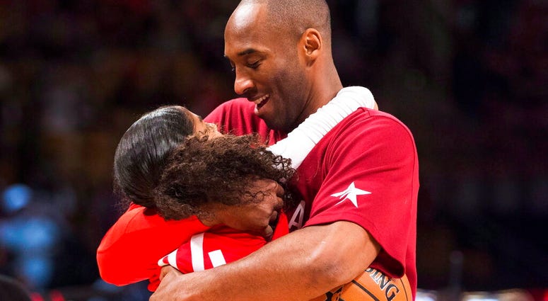 In this Feb. 14, 2016, file photo, Los Angeles Lakers Kobe Bryant (24) hugs his daughter Gianna on the court in warm-ups before first half NBA All-Star Game basketball action in Toronto. Los Angeles Lakers Kobe Bryant (24) hugs his daughter Gianna on the court in warm-ups before first half NBA All-Star Game basketball action in Toronto.
