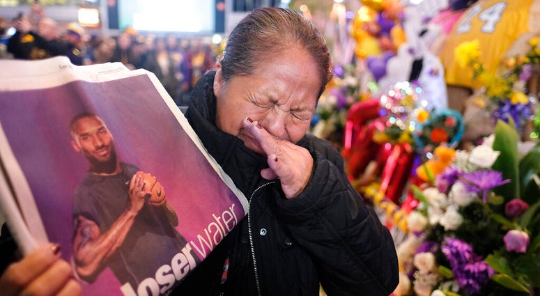 Ana Sebastian, from Guatemala, shows a copy of newspaper with a picture of the late Kobe Bryant at a memorial for Bryant near Staples Center, Monday, Jan. 27, 2020, in Los Angeles. Ana Sebastian, from Guatemala, shows a copy of newspaper with a picture of the late Kobe Bryant at a memorial for Bryant near Staples Center, Monday, Jan. 27, 2020, in Los Angeles.