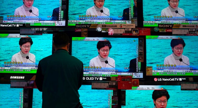 A man wears protective face masks stands in front of TV screens broadcasting Hong Kong Chief Executive Carrie Lam delivering a speech in Hong Kong, Monday, Feb. 3, 2020. A man wears protective face masks stands in front of TV screens broadcasting Hong Kong Chief Executive Carrie Lam delivering a speech in Hong Kong, Monday, Feb. 3, 2020.