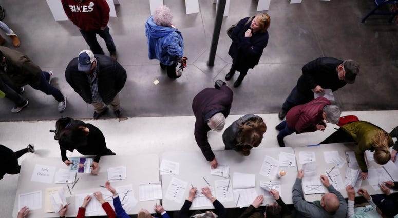 Caucus goers check in at a caucus at Roosevelt High School, Monday, Feb. 3, 2020, in Des Moines, Iowa. Caucus goers check in at a caucus at Roosevelt High School, Monday, Feb. 3, 2020, in Des Moines, Iowa.
