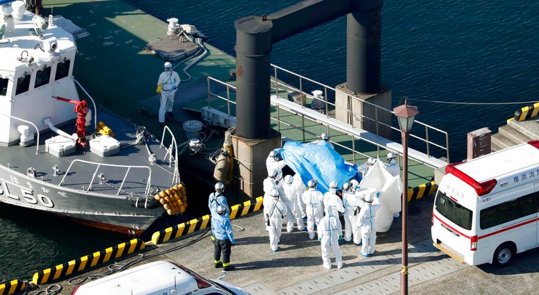 Medical workers in protective suits lead a passenger tested positive for a new coronavirus from the cruise ship Diamond Princess at Yokohama Port in Yokohama, south of Tokyo, Wednesday, Feb. 5, 2020. Medical workers in protective suits lead a passenger tested positive for a new coronavirus from the cruise ship Diamond Princess at Yokohama Port in Yokohama, south of Tokyo, Wednesday, Feb. 5, 2020.