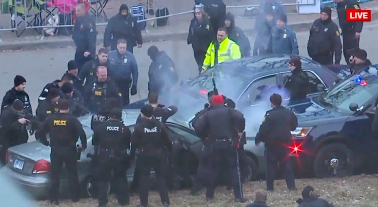 In this image take from video, law enforcement personnel surround a car after it was stopped as the driver approached the crowd near Union Station attending the Super Bowl parade and rally for the Kansas City Chief in Kansas City, Mo., Feb. 5, 2020. Police surround a car during the Chiefs' Super Bowl parade