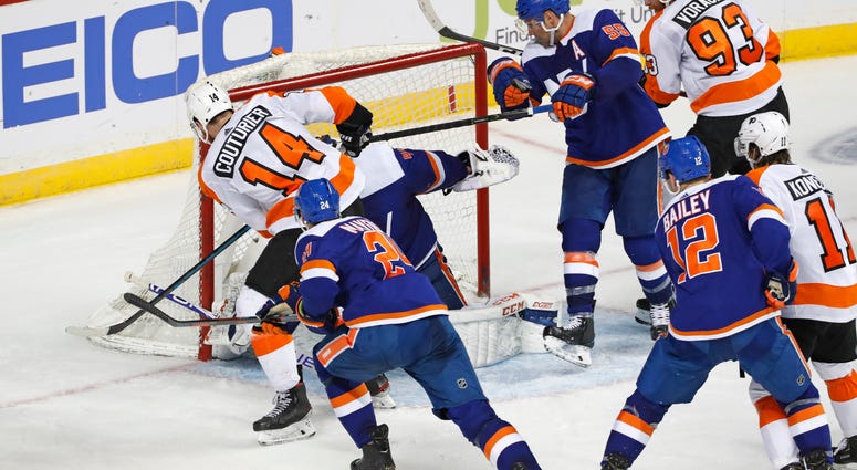 Philadelphia Flyers center Sean Couturier (14) scores a game-tying goal against New York Islanders goaltender Semyon Varlamov (40) during the third period of an NHL hockey game, Tuesday, Feb. 11, 2020, in New York. Philadelphia Flyers center Sean Couturier (14) scores a game-tying goal against New York Islanders goaltender Semyon Varlamov (40) during the third period of an NHL hockey game, Tuesday, Feb. 11, 2020, in New York.