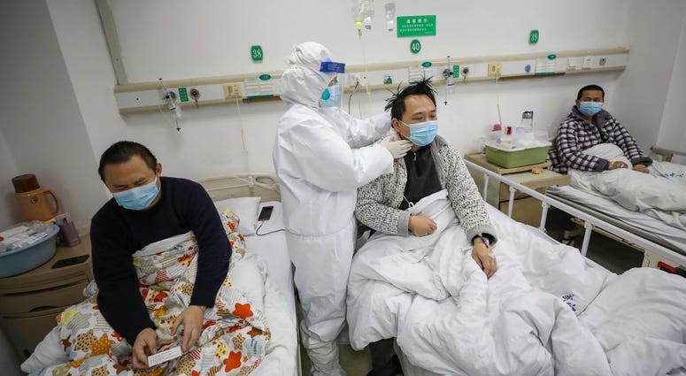 A doctor checks the conditions of a patient in Jinyintan Hospital, designated for critical COVID-19 patients, in Wuhan in central China's Hubei province Thursday, Feb. 13, 2020. A doctor checks the conditions of a patient with COVID-19.