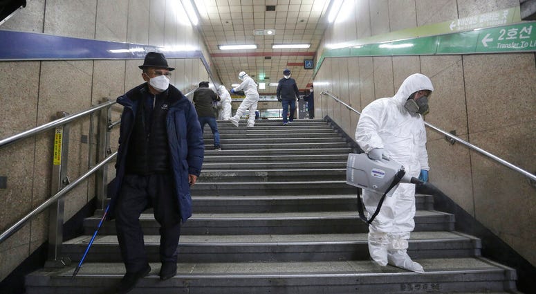 Workers wearing protective gears spray disinfectant as a precaution against the coronavirus at a subway station in Seoul, South Korea. Workers wearing protective gears spray disinfectant as a precaution against the coronavirus at a subway station in Seoul, South Korea.
