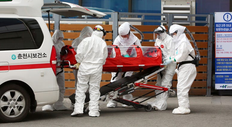 South Korea on Saturday reported a six-fold jump in viral infections in four days to 346. Medical workers wearing protective gears carry a patient infecting with a new coronavirus to a hospital in Chuncheon, South Korea, Saturday, Feb. 22, 2020.