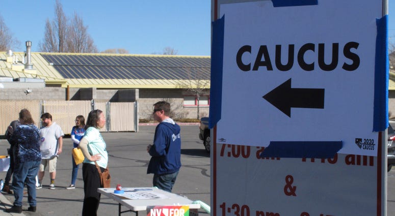 Volunteers for various campaigns talk to voters as they enter a presidential caucus site at Mendive Middle School in Sparks, Nev., on Saturday, Feb. 22, 2020. Volunteers for various campaigns talk to voters as they enter a presidential caucus site at Mendive Middle School in Sparks, Nev., on Saturday, Feb. 22, 2020.