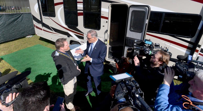 Washington Gov. Jay Inslee, joined by Nathan Weed, left, Dept. of Health incident commander, tours the group of RV's set-up for potential isolation and quarantine of COVID-19 patients in Grand Mound, Wash. Washington Gov. Jay Inslee, joined by Nathan Weed, left, Dept. of Health incident commander, tours the group of RV's set-up for potential isolation and quarantine of COVID-19 patients in Grand Mound, Wash.