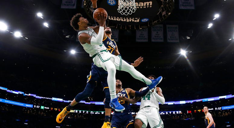 Boston Celtics' Marcus Smart is knocked off balance while going for a shot against Utah Jazz's Rudy Gobert (27) during the fourth quarter of an NBA basketball game Friday, March 6, 2020, in Boston. Boston Celtics' Marcus Smart is knocked off balance while going for a shot against Utah Jazz's Rudy Gobert (27) during the fourth quarter of an NBA basketball game Friday, March 6, 2020, in Boston.