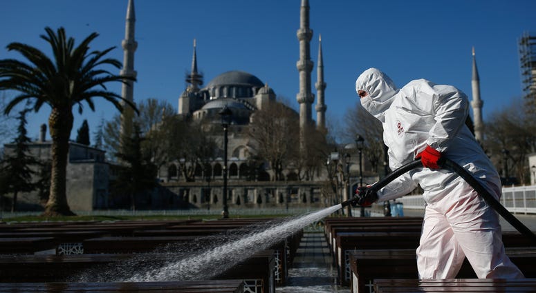 The new COVID-19 coronavirus can cause mild or moderate symptoms, but for some it can cause severe illness. A municipality worker wearing a face mask and protective suits disinfects chairs outside the the historical Sultan Ahmed Mosque, also known as Blue Mosque, amid the coronavirus outbreak, in Istanbul, Saturday, March 21, 2020.
