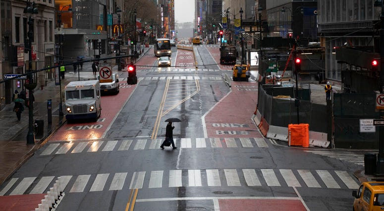 A commuter crosses 42nd Street in front of Grand Central Terminal during morning rush hour, Monday, March 23, 2020, in New York. Gov. Andrew Cuomo has ordered most New Yorkers to stay home from work to slow the coronavirus pandemic. A commuter crosses 42nd Street in front of Grand Central Terminal during morning rush hour, Monday, March 23, 2020, in New York. Gov. Andrew Cuomo has ordered most New Yorkers to stay home from work to slow the coronavirus pandemic.