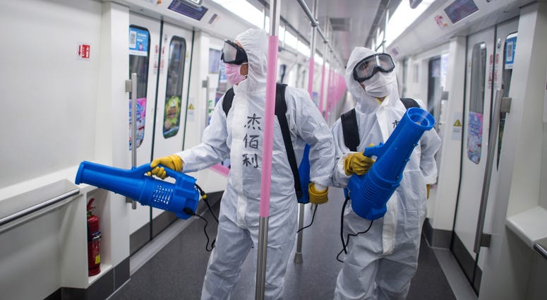 In this March 23, 2020 photo released by Xinhua News Agency, workers disinfect a subway train in preparation for the restoration of public transport in Wuhan, in central China's Hubei province. In this March 23, 2020 photo released by Xinhua News Agency, workers disinfect a subway train in preparation for the restoration of public transport in Wuhan, in central China's Hubei province.