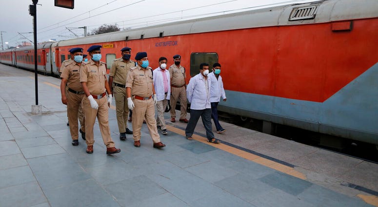 Railway officials walk through a deserted railway station platform in Prayagraj, India, Tuesday, March 24, 2020. Railway officials walk through a deserted railway station platform in Prayagraj, India, Tuesday, March 24, 2020.