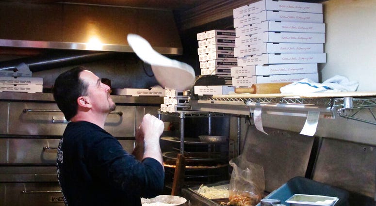In this March 24, 2020, photo, Michael Morin, co-owner of Federico's Pizza in Belmar N.J., makes a pizza In this March 24, 2020, photo, Michael Morin, co-owner of Federico's Pizza in Belmar N.J., makes a pizza