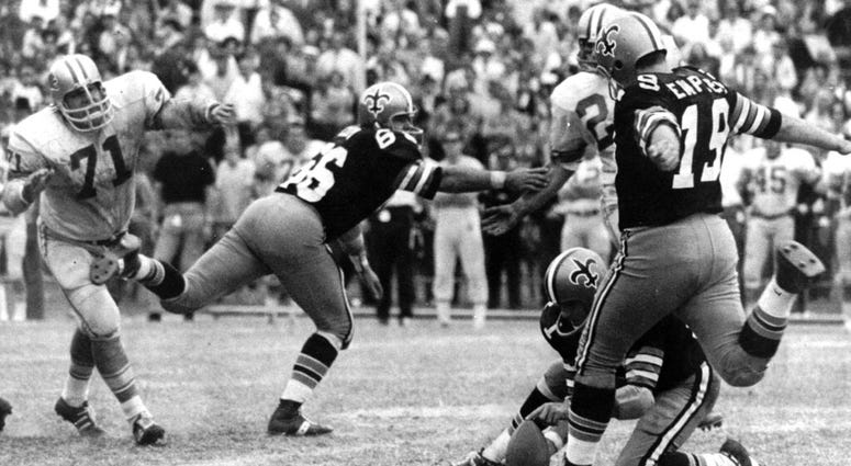 FILE - In this Nov. 8, 1970, file photo, New Orleans Saints' Tom Dempsey (19) moves up to kick a 63-yard field goal as teammate Joe Scarpati holds the ball and Detroit Lions' Alex Karras (71) rushes in while Saints' Bill Cody (66) blocks, in New Orleans. New Orleans Saints' Tom Dempsey (19) moves up to kick a 63-yard field goal as teammate Joe Scarpati holds the ball and Detroit Lions' Alex Karras (71) rushes in while Saints' Bill Cody (66) blocks, in New Orleans.