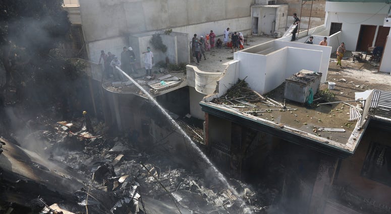 Fire brigade staff try to put out fire caused by plane crash in Karachi, Pakistan, Friday, May 22, 2020. Fire brigade staff try to put out fire caused by plane crash in Karachi, Pakistan, Friday, May 22, 2020.