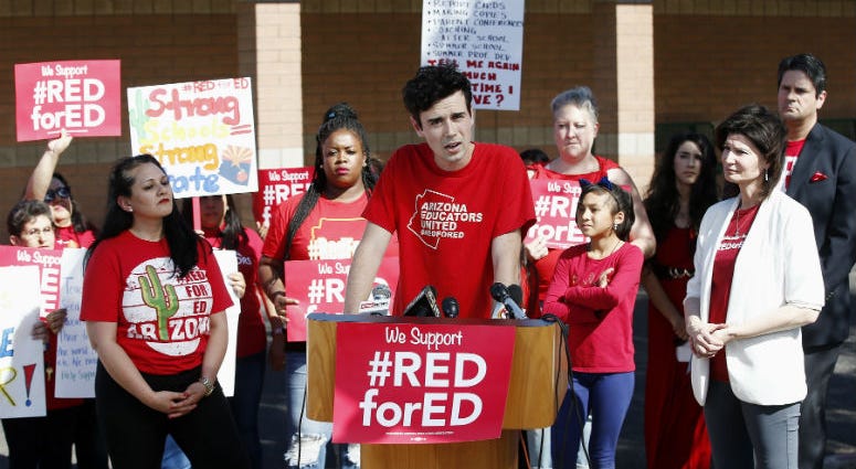Music teacher Noah Karvelis, center, who helped organize Arizona Educators United, speaks at a news conference at the Esperanza Elementary School in Isaac School District. Music teacher Noah Karvelis