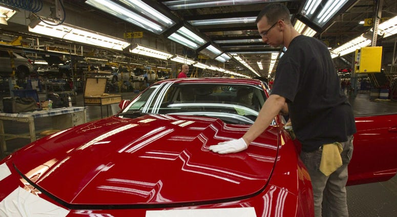 In this June 10, 2011, file photo, a worker checks the paint on a Camaro at the GM factory in Oshawa, Ontario. In this June 10, 2011, file photo, a worker checks the paint on a Camaro at the GM factory in Oshawa, Ontario.