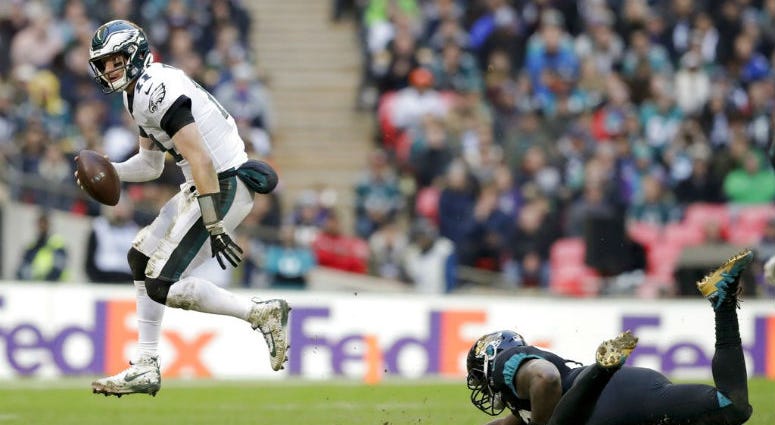 Philadelphia Eagles quarterback Carson Wentz (11) passes the ball during the first half of an NFL football game against Jacksonville Jaguars at Wembley stadium in London, Sunday, Oct. 28, 2018.