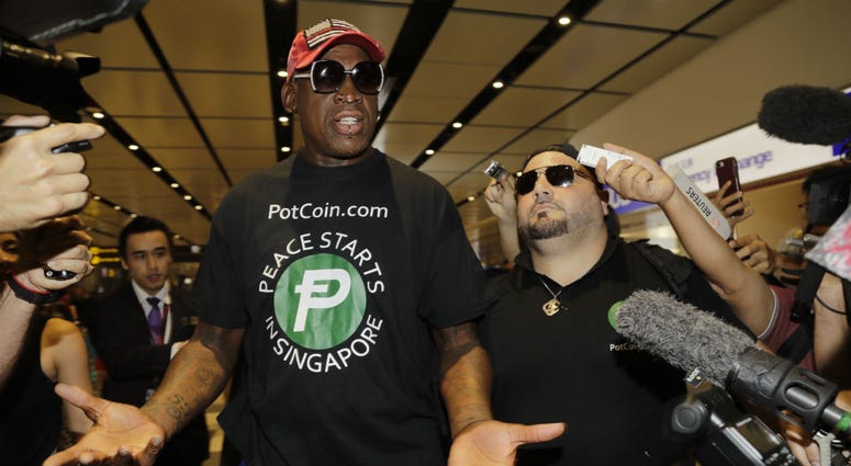 Former NBA basketball player Dennis Rodman, and Chris Volo, right, arrive at Singapore's Changi Airport on Tuesday, June 12, 2018. Former NBA basketball player Dennis Rodman
